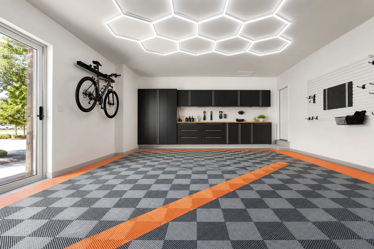 Garagem residencial clara com piso modular cinzento e faixa laranja
